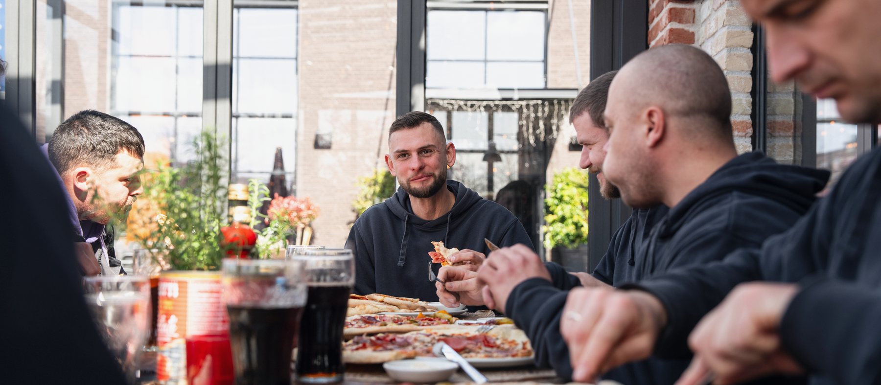 Das Team von Deak sitzt nach Feierabend beim Essen zusammen.