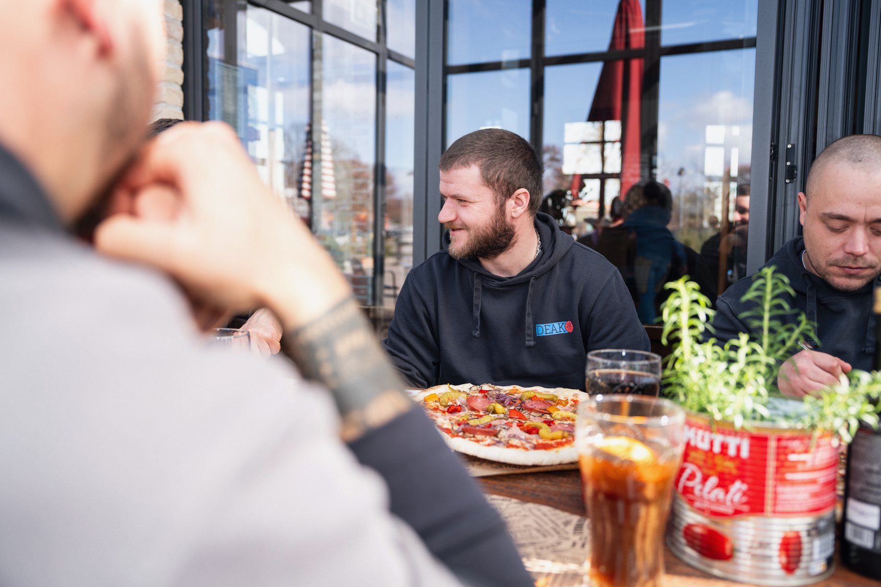 Das Team sitzt beim Mittagessen zusammen an einem Tisch.